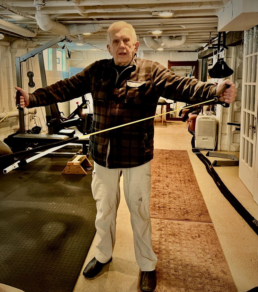 Older fit man exercising with bands.