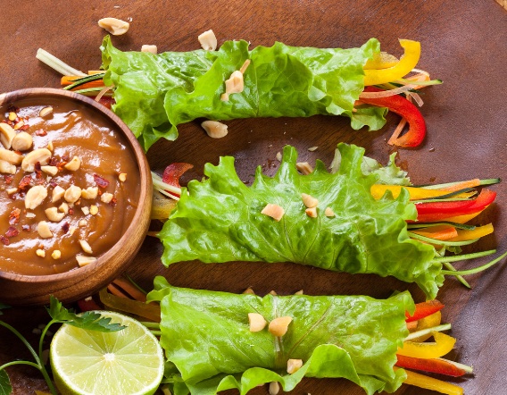 Chicken wrapped in lettuce with veggies and a side of peanut sauce.