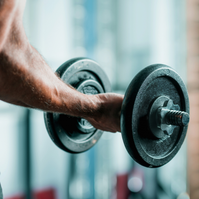 Man holding a dumbbell and performing a bicep curl.