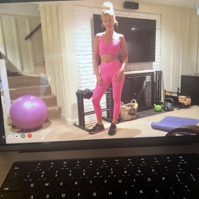 Fit woman standing in her home gym with dumbbells.