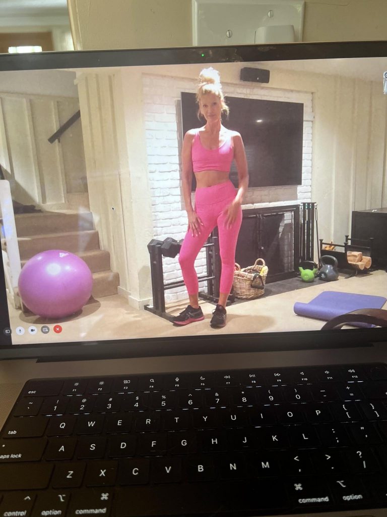 Fit woman standing in her home gym with dumbbells.