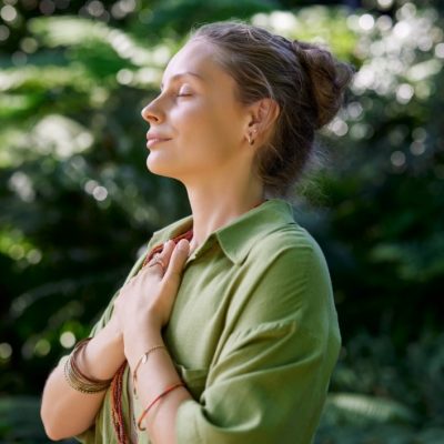 Woman crossing her arms across her chest smiling, happy and peaceful.